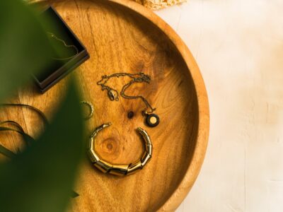 A wooden bowl with jewelry on it Description automatically generated with low confidence