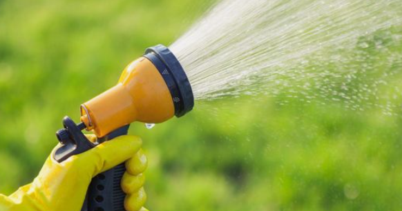 Soaker hoses in action sprays water on a green field