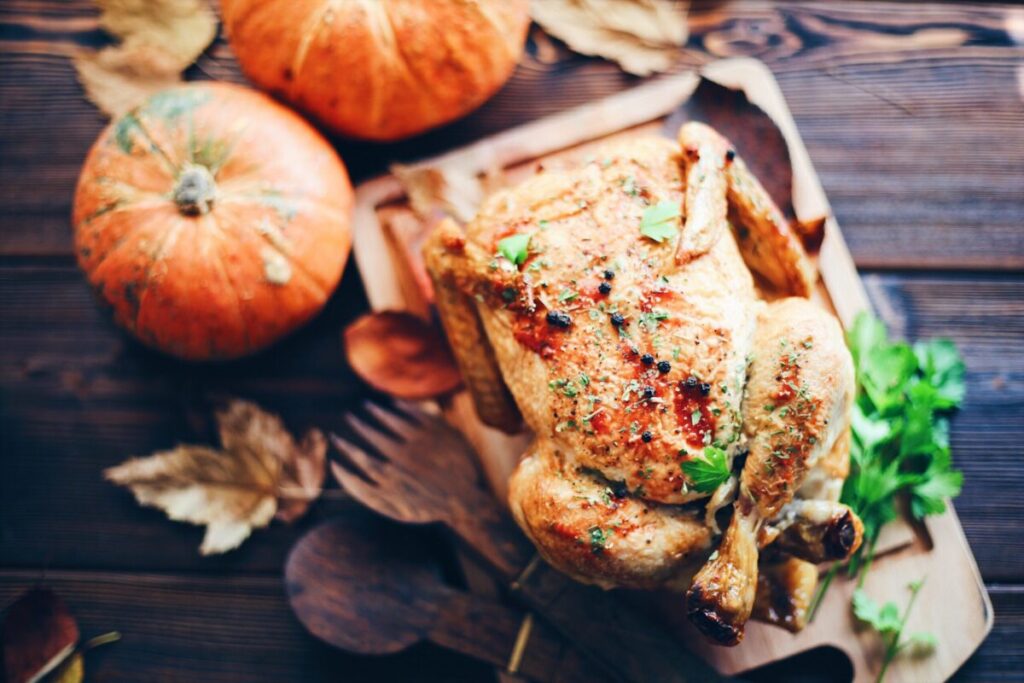 a roasted chicken alongside pumpkins, highlighting the versatility and cooking diversity of chicken.